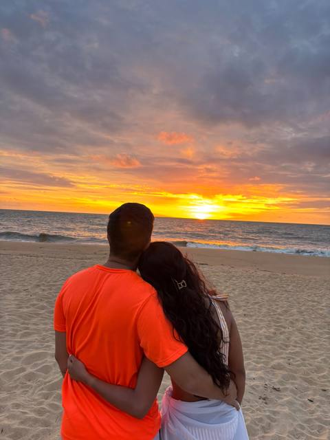 Sara e João vendo o pôr do sol na praia